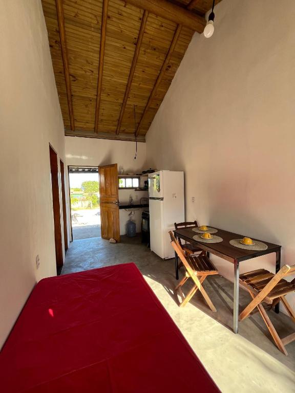 a living room with a table and a kitchen at Casa Mojubá in Porto Seguro
