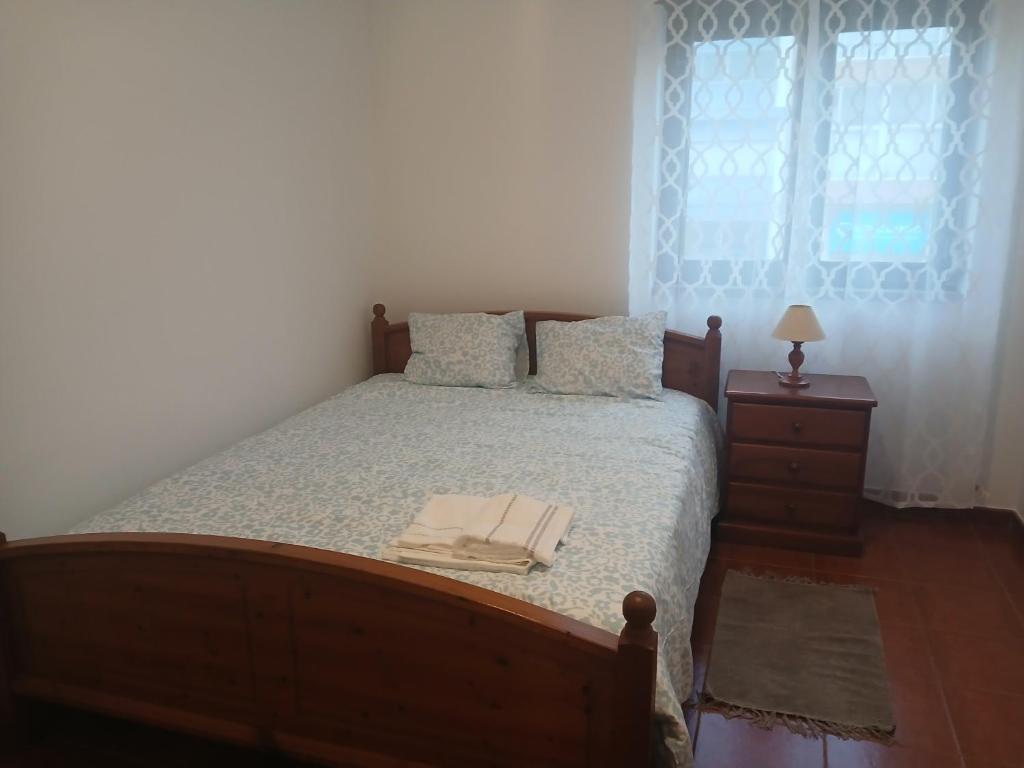 a bedroom with a bed and a dresser and a window at Centro Da Vila in Lourinhã