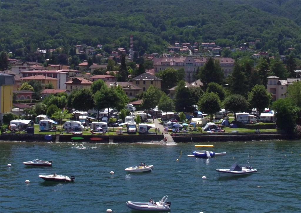 un gruppo di barche in un bacino idrico con una città di Camping Parisi a Baveno