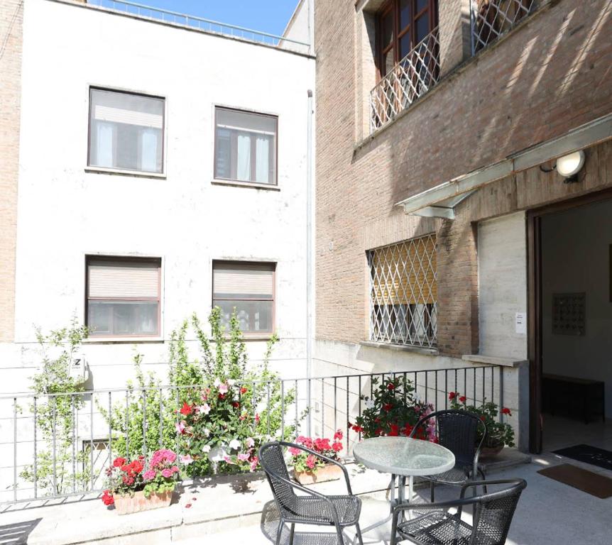 a patio with a table and chairs in front of a building at OSTELLO del Lago in Grottaferrata