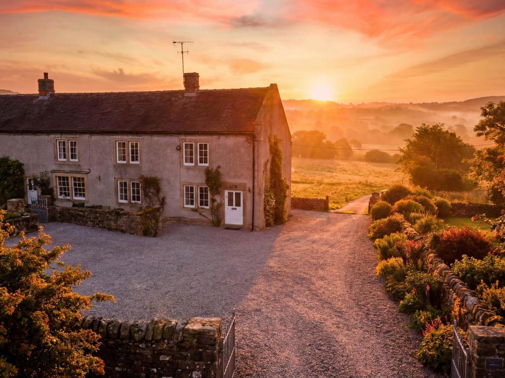 an old house in a field at sunset at The Farmhouse in Bakewell
