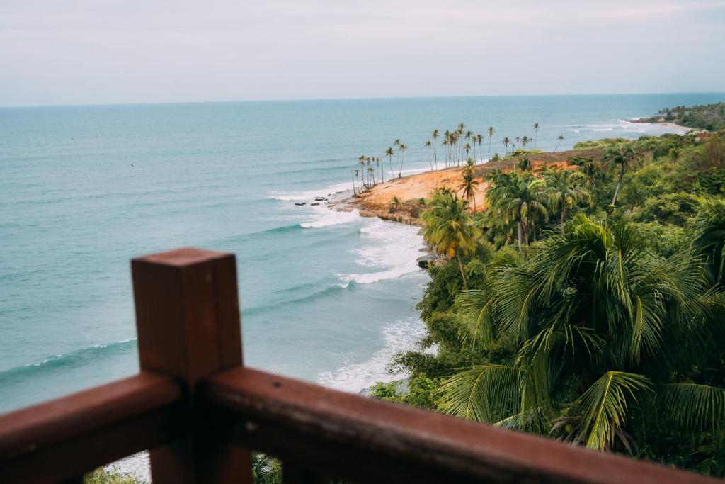 a view of a beach with palm trees and the ocean at Casa triplex Lagoinha in Lagoinha