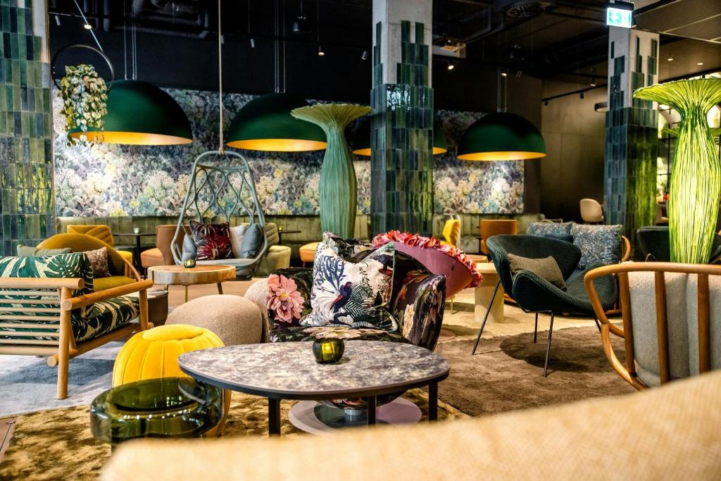 a room with couches and chairs and a table at Motel One München-Hauptbahnhof in Munich