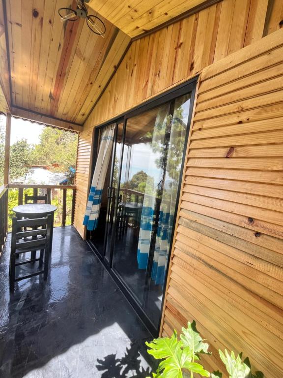 a screened in porch of a house with a wooden wall at Cabaña OLIN in San Mateo Río Hondo