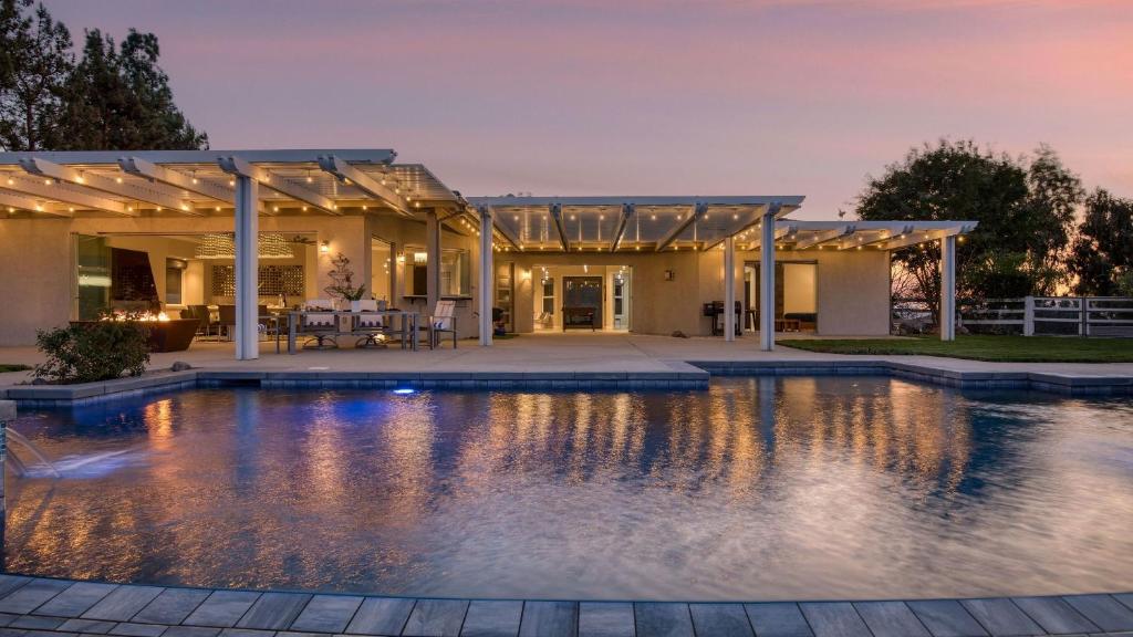 a swimming pool in front of a house at Summit Ranch by AvantStay in Temecula