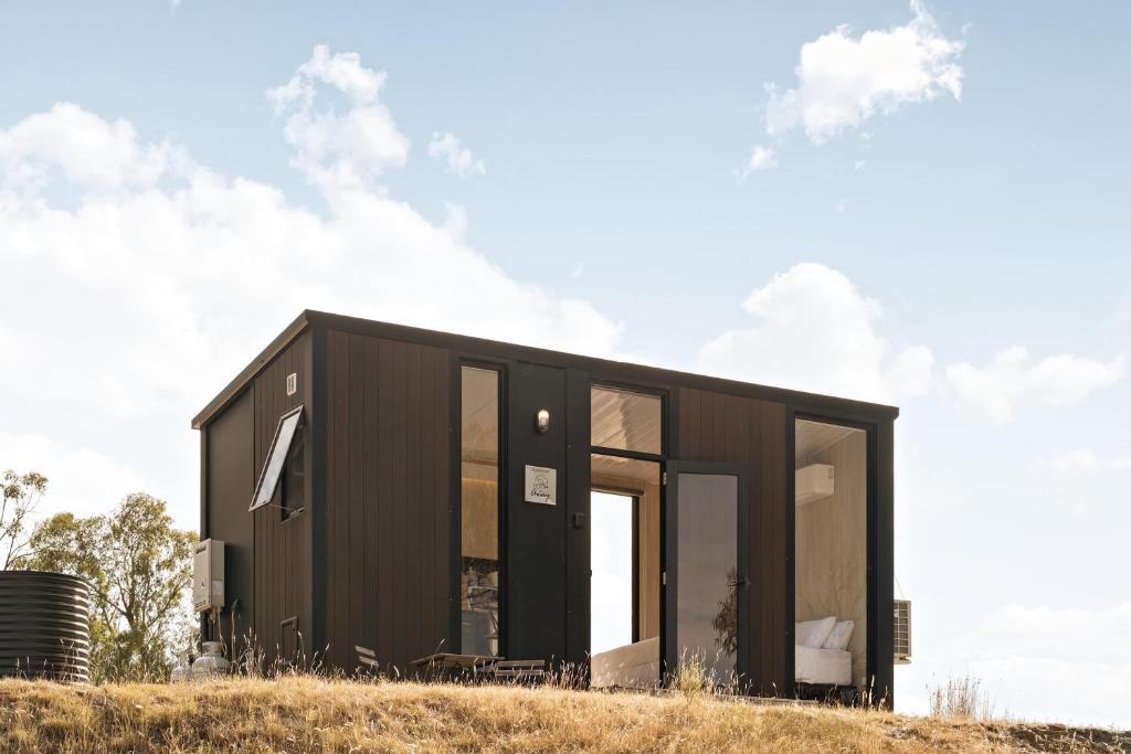a black house on top of a hill at Bunjil by Tiny Away in Steels Creek