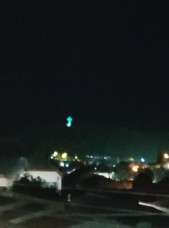 a green object flying in the sky at night at Apartamentos 22 de mayo in Puerto Montt