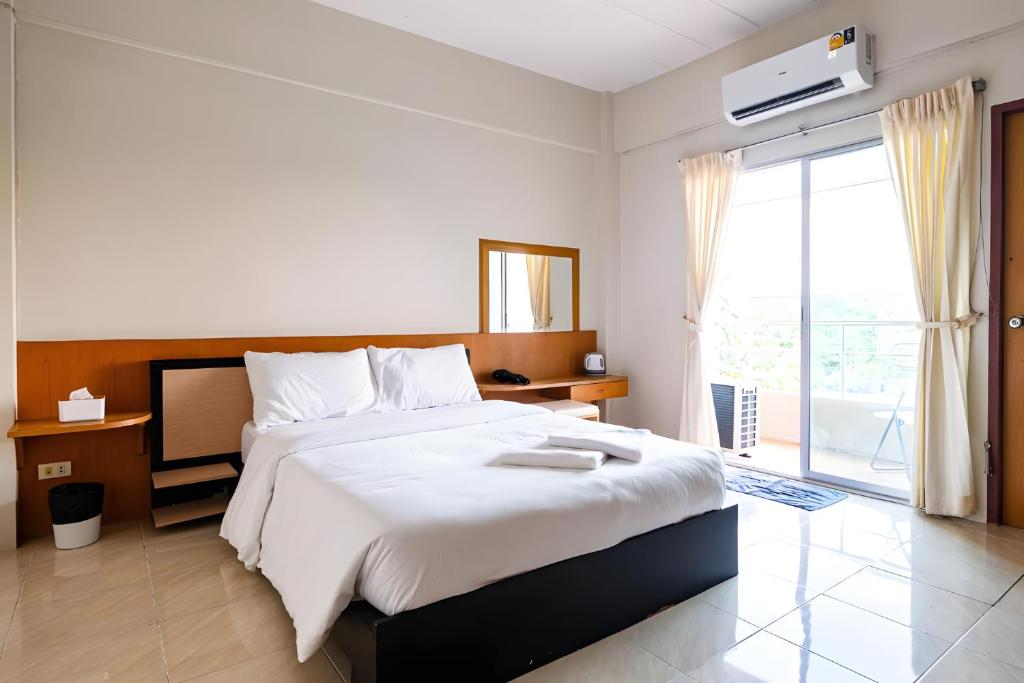 a bedroom with a large bed and a large window at GO INN Suvarnabhumi Airport โก อินน์ สนามบินสุวรรณภูมิ in Lat Krabang