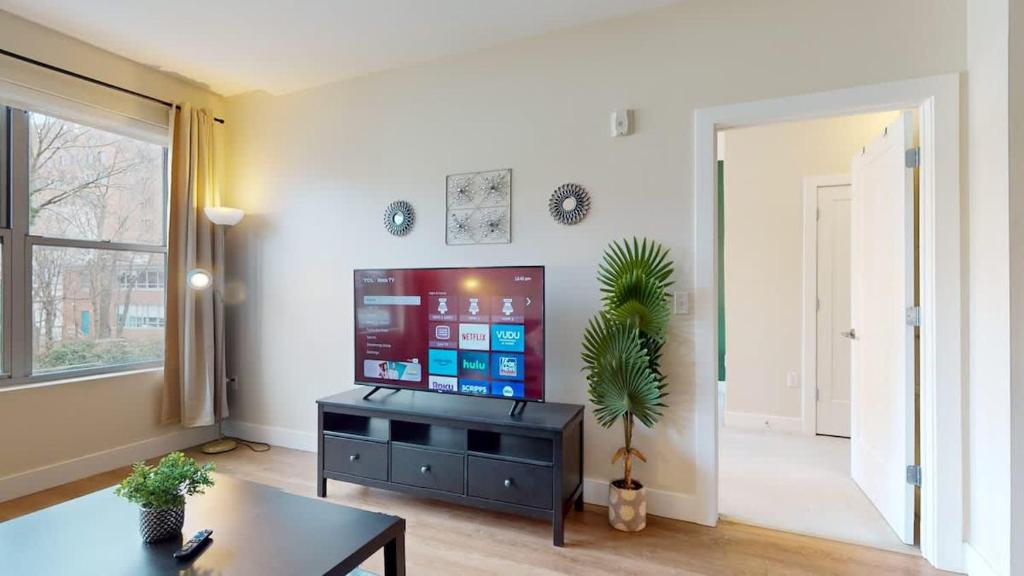 a living room with a tv and a table at Stylish Home with Free Parking in Stamford