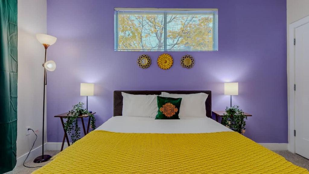 a purple bedroom with a bed with a yellow blanket at Stylish Home and Cozy in Stamford