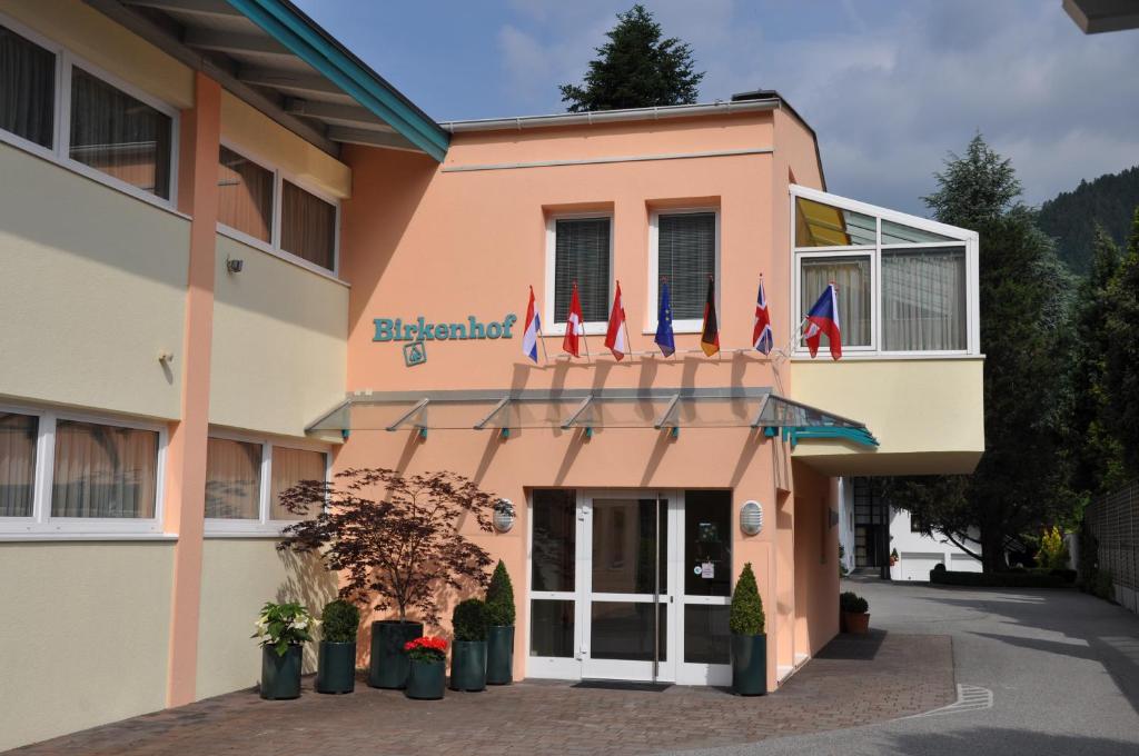 a pink building with flags in front of it at Ferienapartments Birkenhof in Döbriach