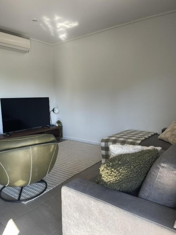 a living room with a couch and a flat screen tv at Stunning Cable Beach - Unit in Cable Beach