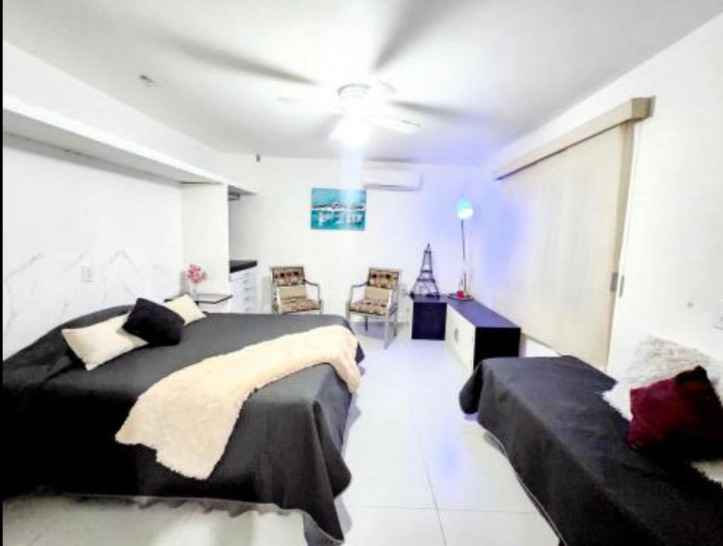 a bedroom with two beds and a ceiling fan at Departamento Getsemani in Hermosillo