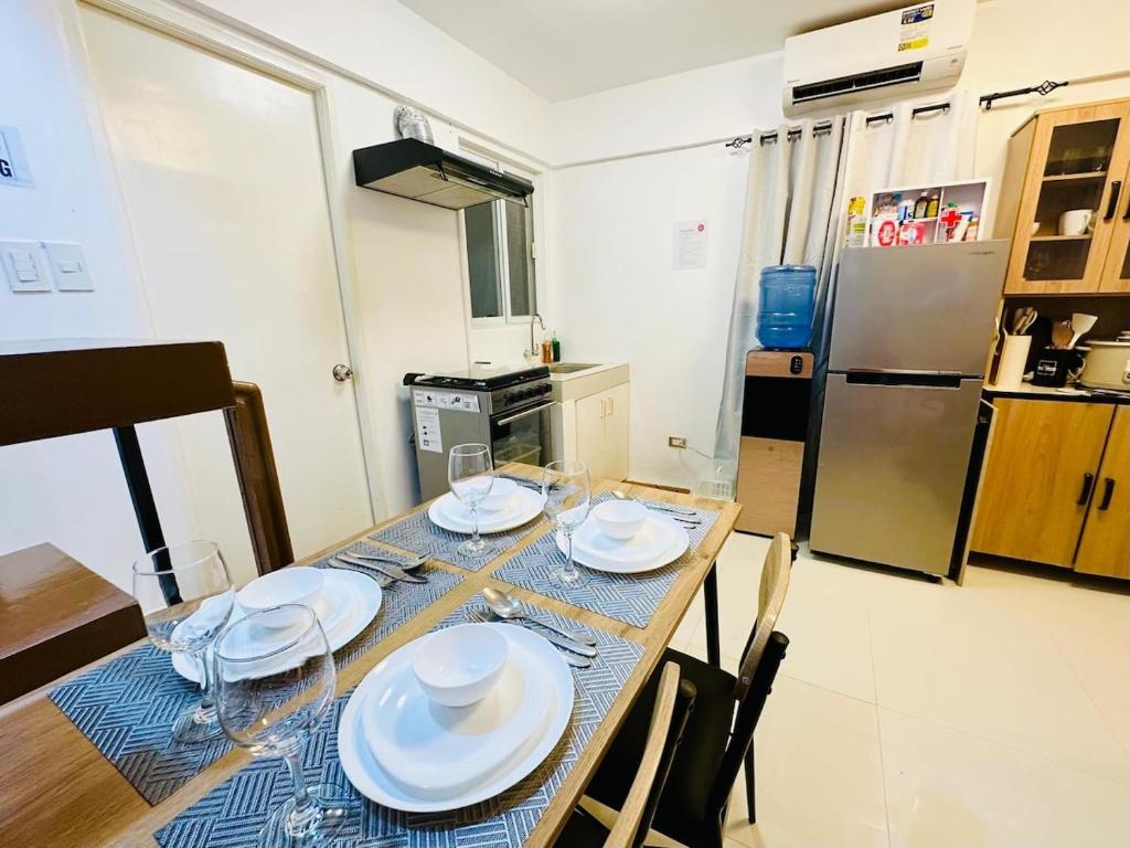 a kitchen with a table with plates and wine glasses at Casa Del Sol! 2BR Puerto Princesa in Puerto Princesa City