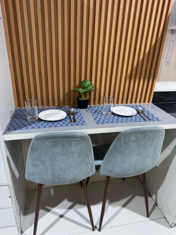 a table with two chairs and plates and a plant on it at Jo Condotels at Persimmon Tower3 in Cebu City