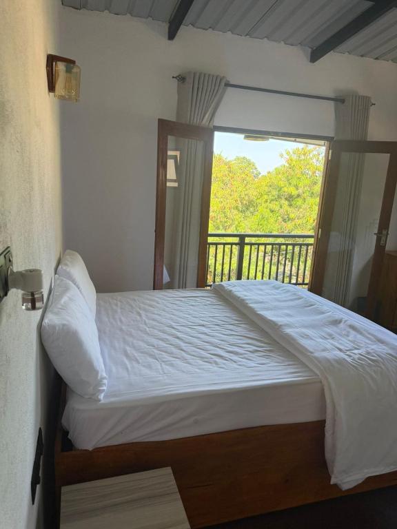 a bed in a room with a balcony with a window at Mount Boutique Villa in Kandy