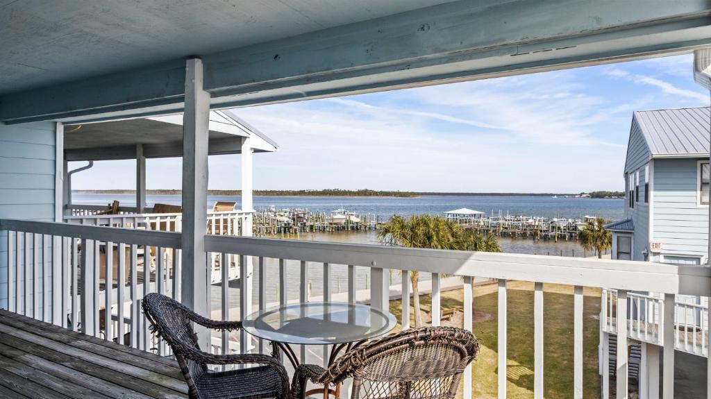 a balcony with two chairs and a table and the ocean at Sixty-Five & Salty Bay View 65 in Orange Beach