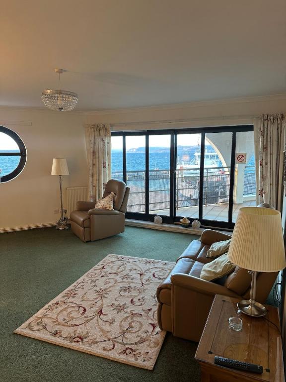 a living room with a couch and chairs and windows at Seaside Penthouse 2 in Largs