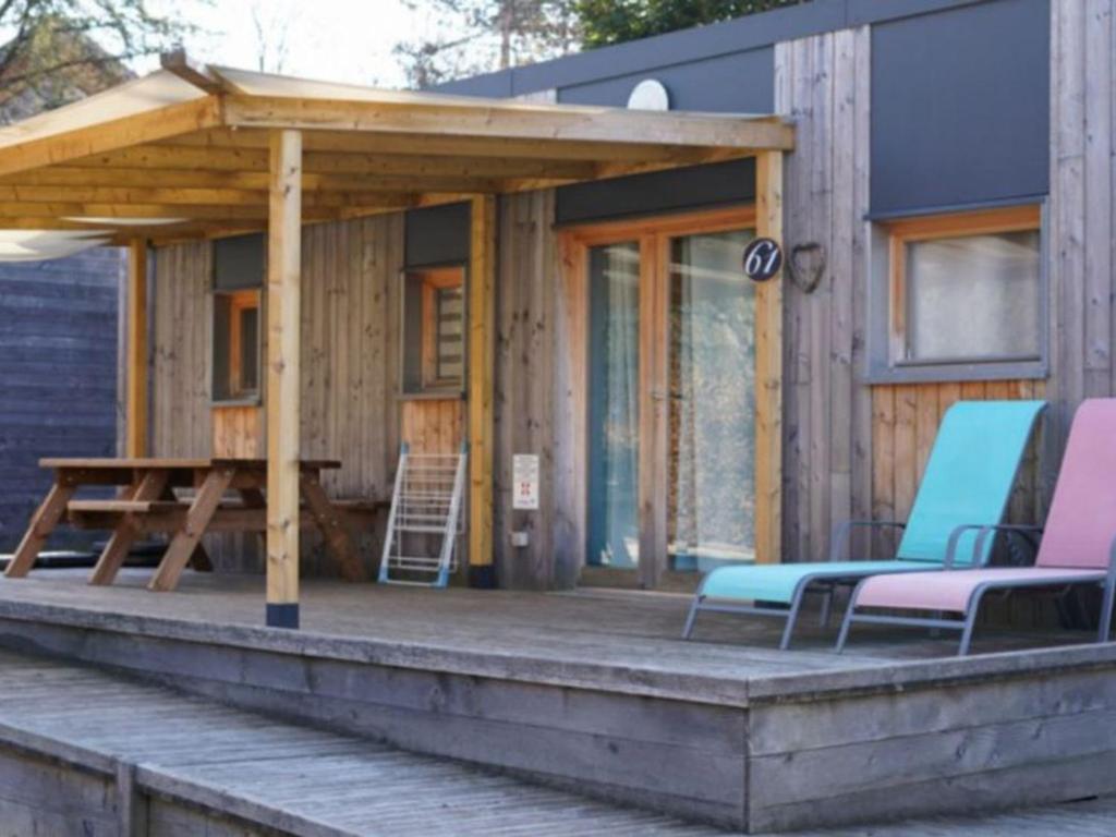 a cabin with a picnic table and chairs on a deck at Chalet accessible - 4 pers - Terrasse - API-1-52-1278 in Challes-les-Eaux