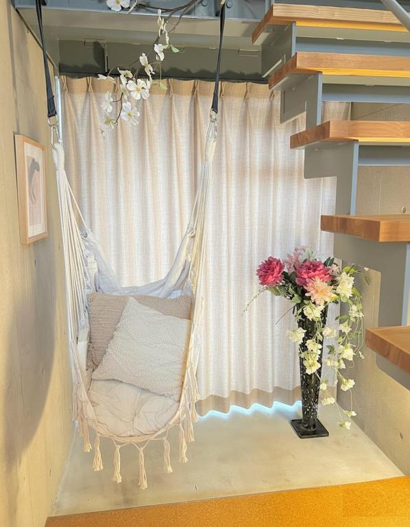 a swing in a room with a vase of flowers at Sunshine in Tokyo