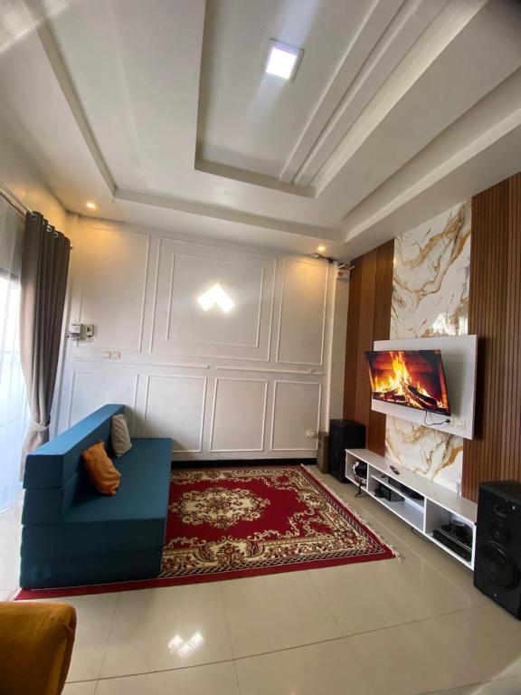a living room with a blue couch and a tv at Ulya Kecil in Diyeng
