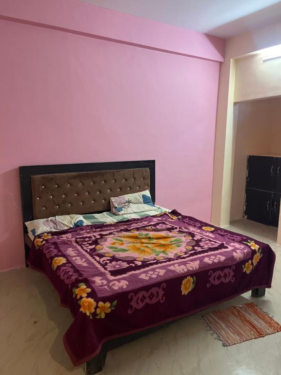 a bed in a room with a purple wall at Hotel flamingo inn in Rewa