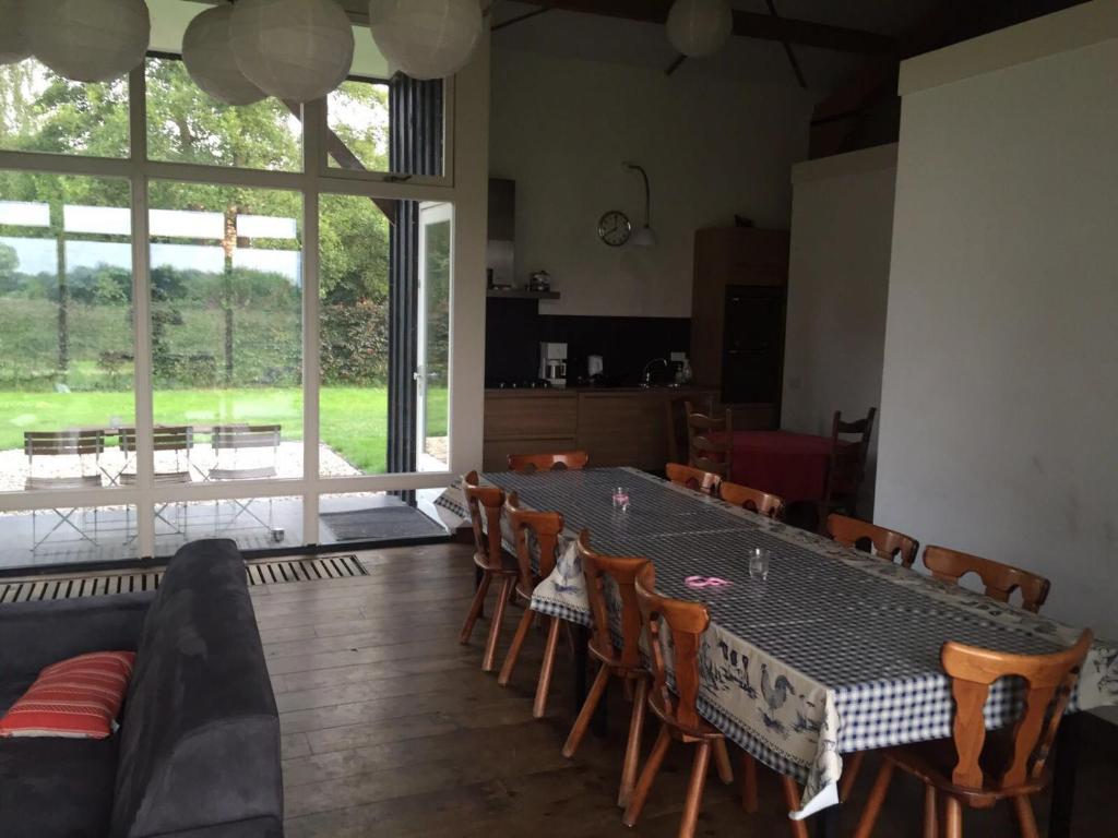 a dining room with a table and chairs and a large window at De Blije Big in Eindhoven