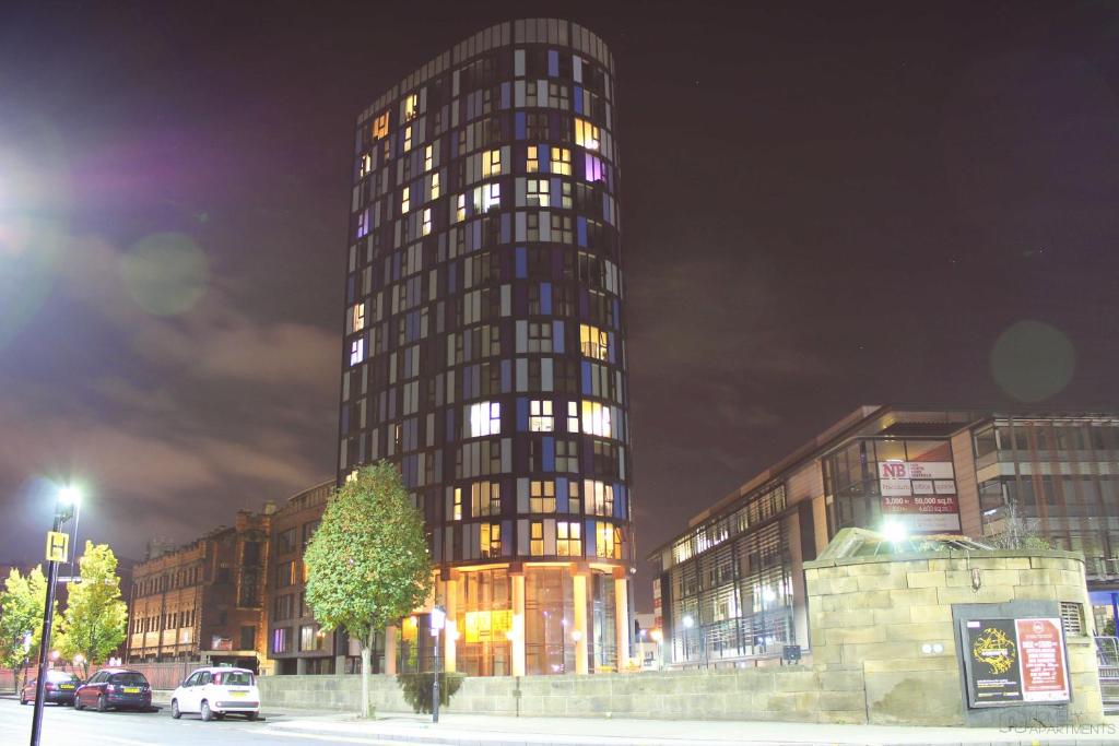 a tall building with many windows at night at Homely Serviced Apartments - Blonk St in Sheffield