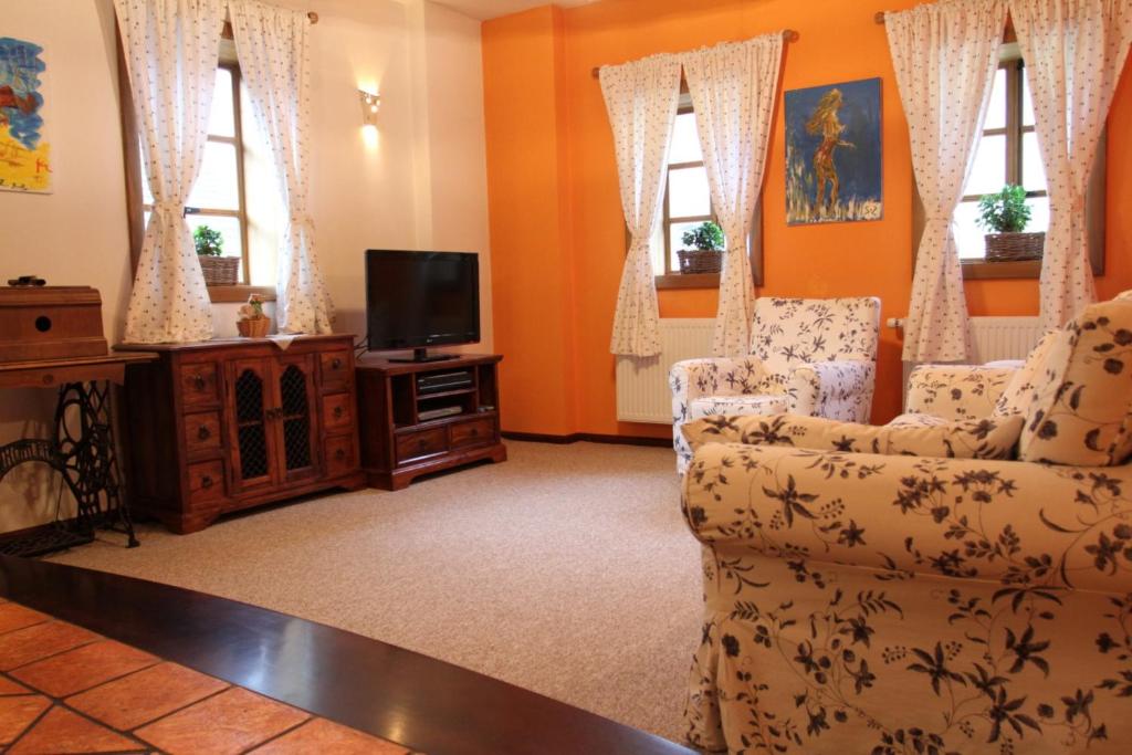 a living room with a tv and two chairs at Apartment Bohinjčan in Bohinj