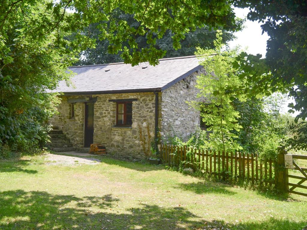 an old stone house with a wooden fence at Great Meadow in Kelly