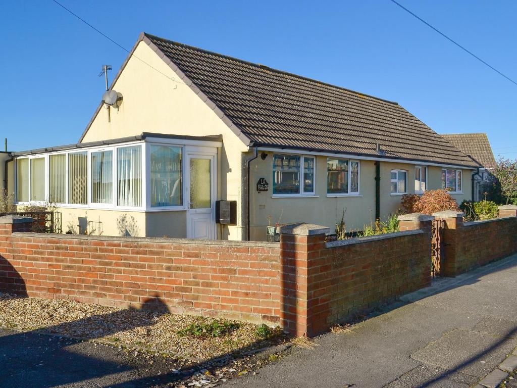a house with a brick fence in front of it at La Falda in Sutton on Sea
