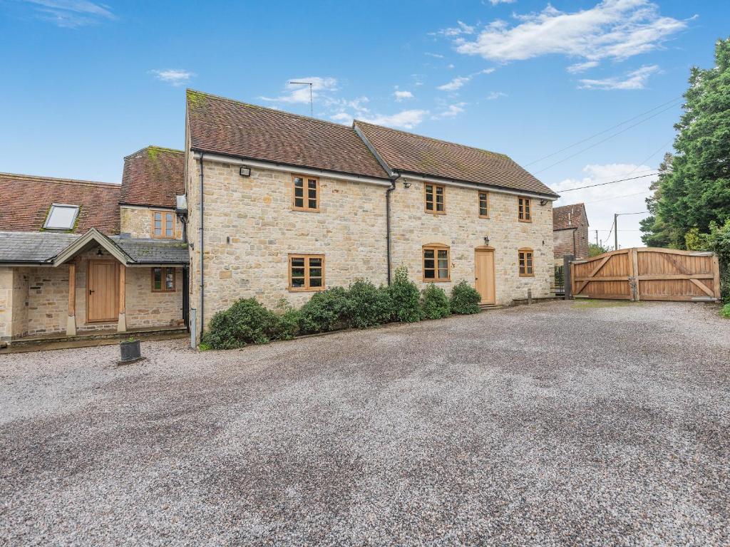 a large brick house with a gate and a driveway at New Inn Farmhouse in Marnhull