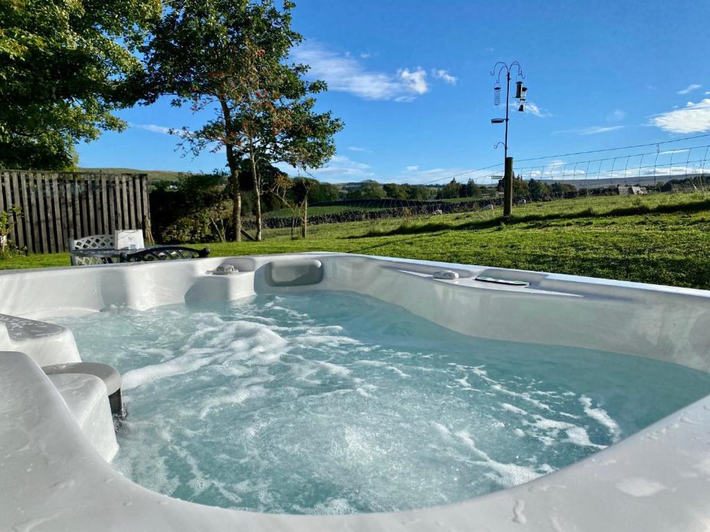 a jacuzzi tub in a yard with a field at Mark Close Milking Parlour in Alston