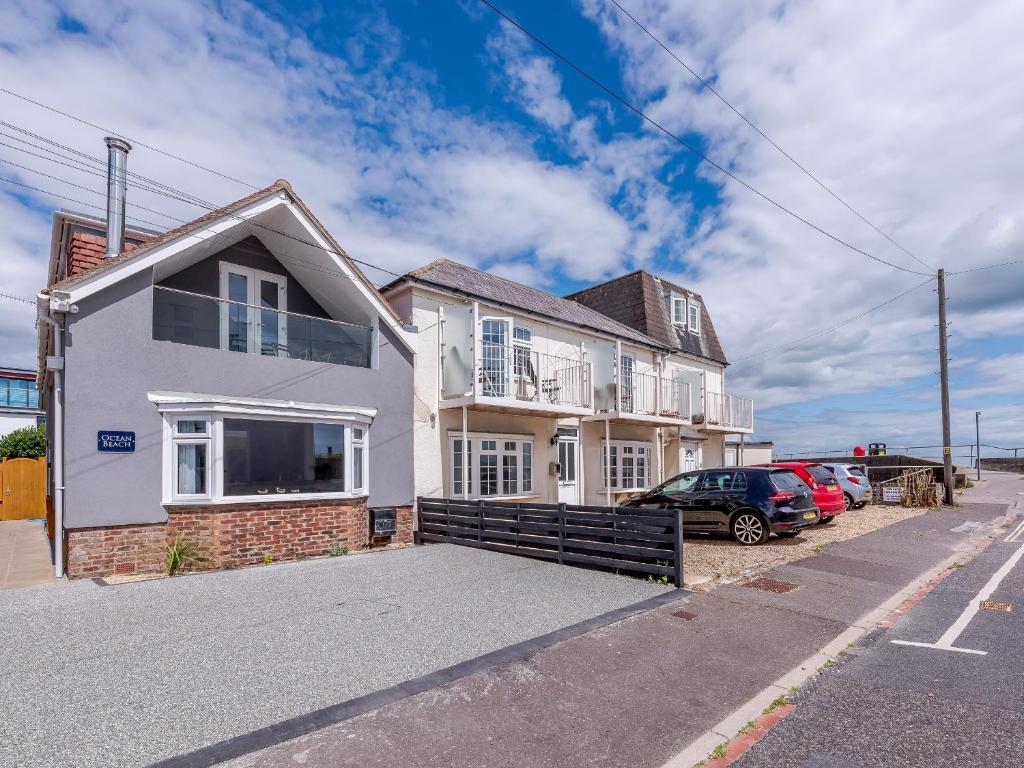 a white house with cars parked in front of it at Ocean Beach in Felpham
