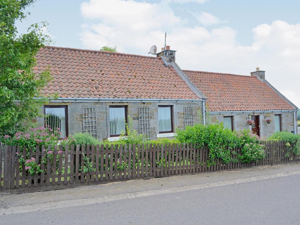 a house with a fence in front of it at Eliza Cottage in Haddington