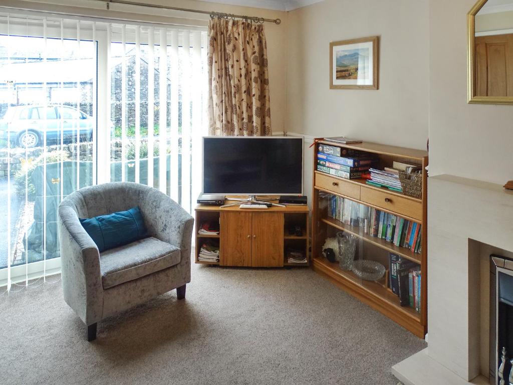 a living room with a chair and a television at Bank View in Settle
