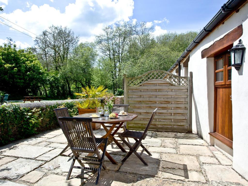 a wooden table and chairs on a patio at The Smithy in Chulmleigh