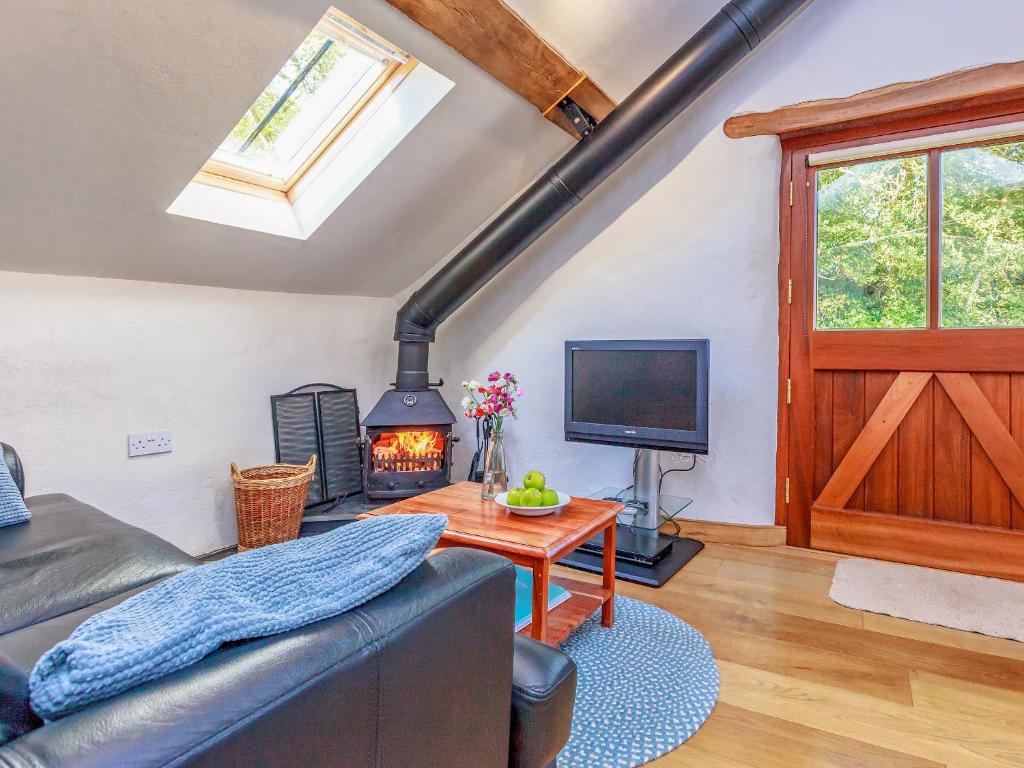 a living room with a couch and a fireplace at Cider Barn in Chulmleigh