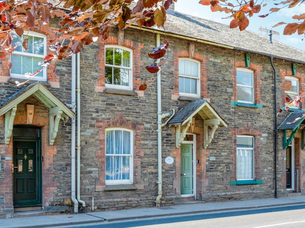 a brick house with green doors and windows at Jame's Cottage in Keswick