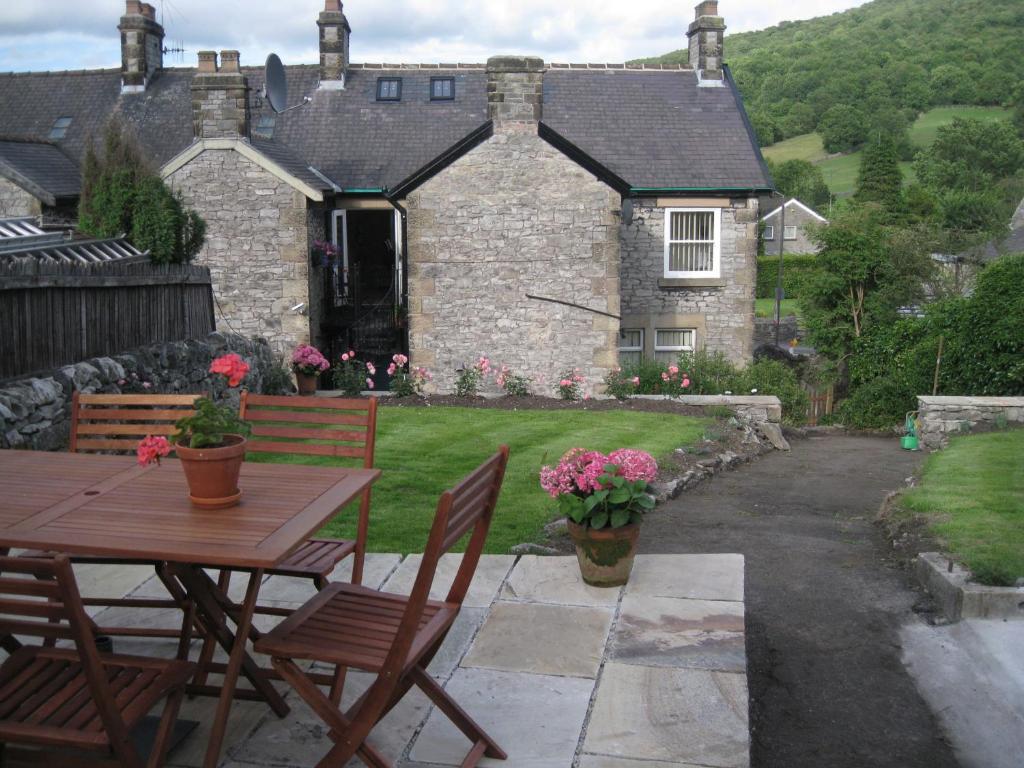 a table and chairs in front of a house at Swallow's Nest in Bradwell