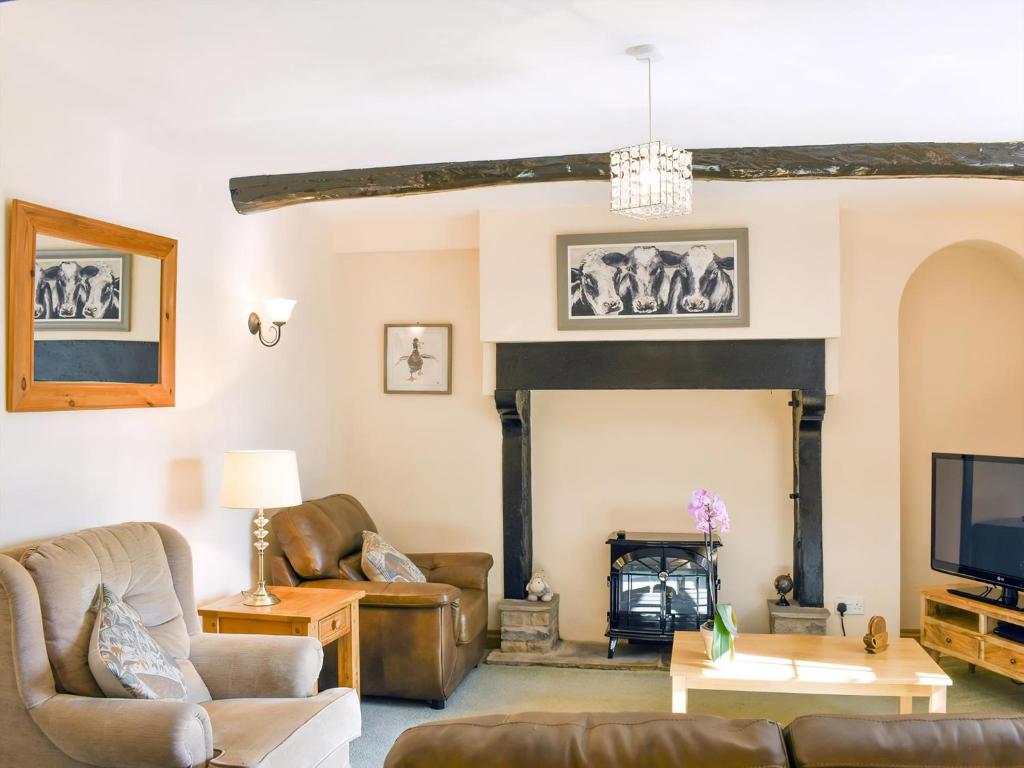 a living room with couches and a fireplace at Gran's Cottage Askrigg in Askrigg