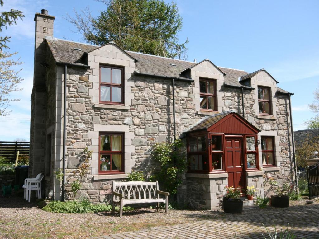 an old stone house with a bench in front of it at Buchanan's Bothy in Glencarse