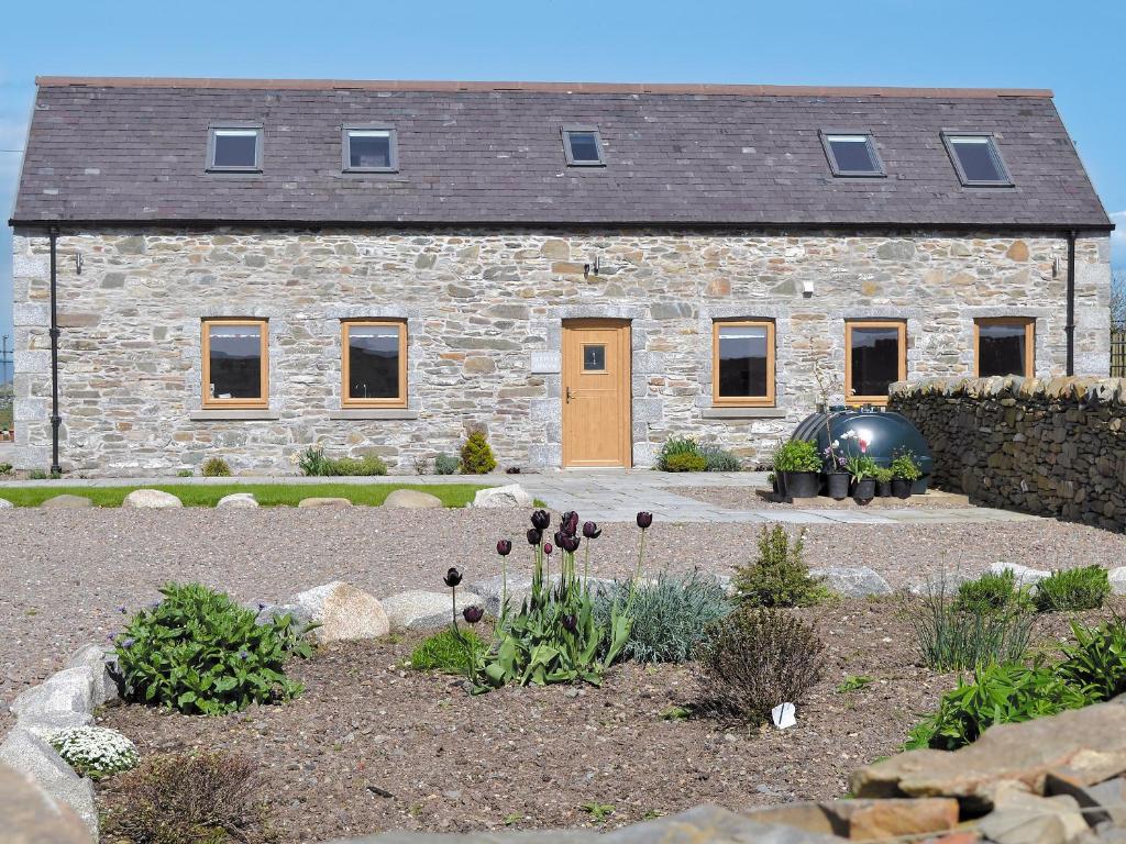 a stone house with a garden in front of it at Cairndoon Steading Whithorn in Carlton