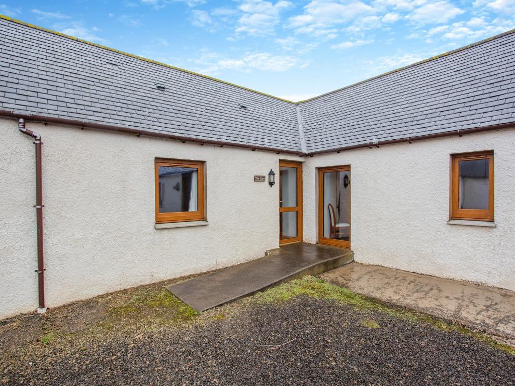 a white brick house with a driveway in front of it at The Barn Mey in Scarfskerry