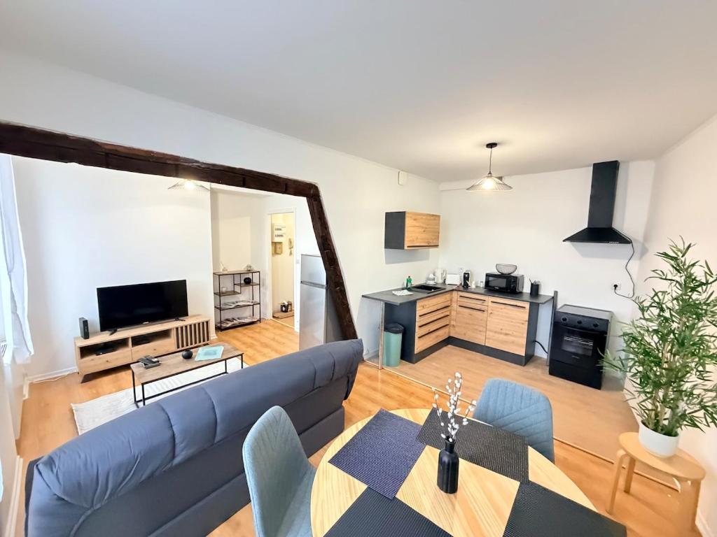 a living room with a blue couch and a table at Le Nid Laonnois Apartment in Laon