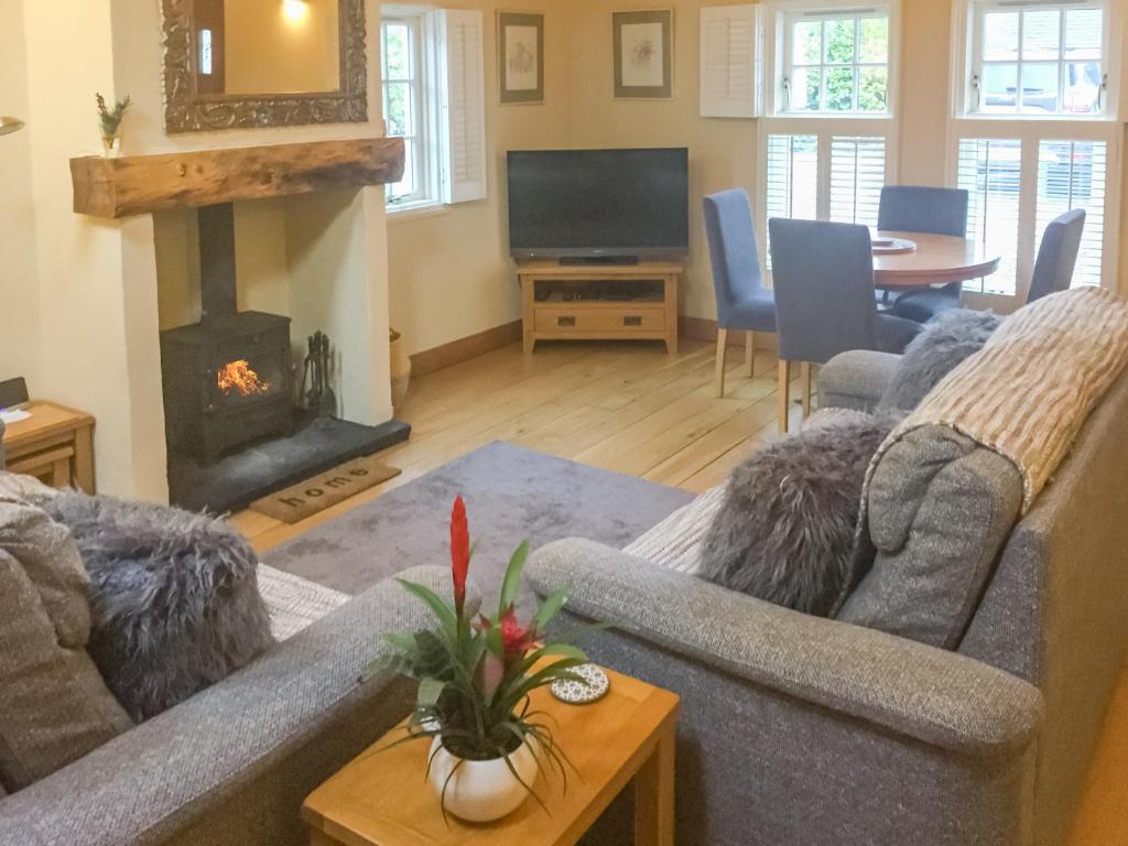 a living room with a couch and a fireplace at Glenfruin Lodge in Helensburgh