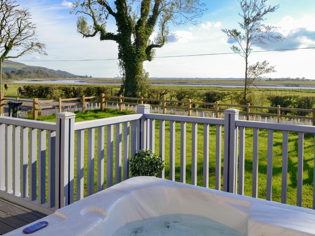 a bath tub on a white fence with a view of a field at Cree Lodge - Uk13636 in Creetown