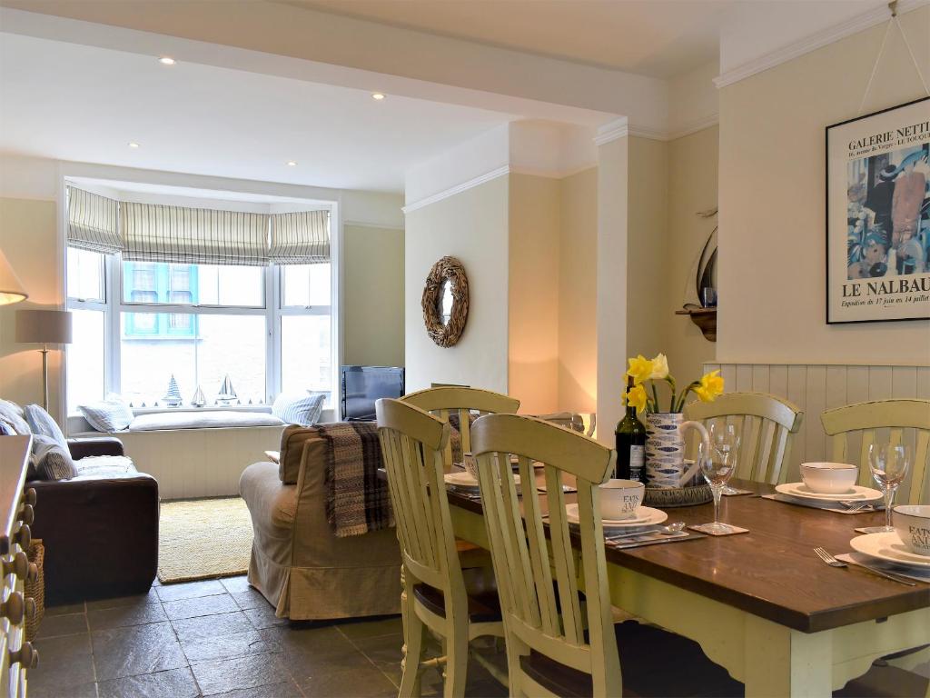 a kitchen and living room with a table and chairs at Sea Star Cottage in Fowey