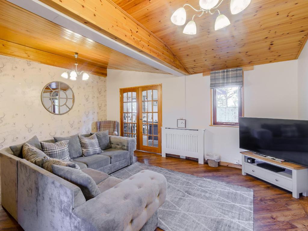 a living room with a couch and a flat screen tv at The Lodge - Uk13202 in Cayton