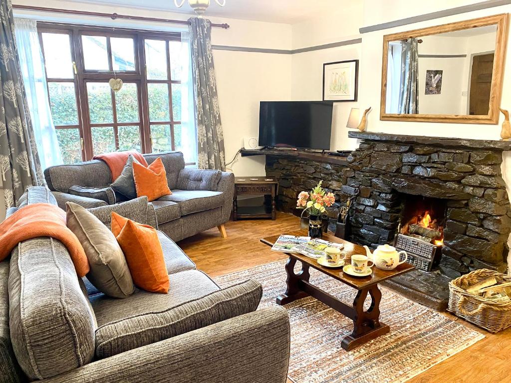 a living room with a couch and a fireplace at Jemima's Cottage in Bassenthwaite